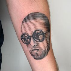 a man's arm with a black and white portrait tattoo on the left forearm