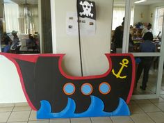 a cardboard pirate ship sitting on top of a tiled floor