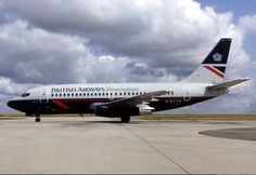 a british airways plane sitting on the tarmac at an airport with clouds in the background