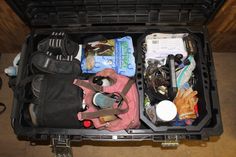 an open suitcase filled with various items on the floor