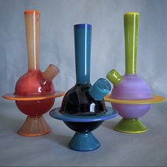 three different colored vases sitting on top of each other