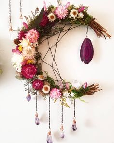 a circular wreath with flowers hanging from it's sides and an amethorate on the side