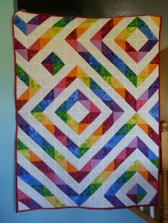 a multicolored quilt hanging on the wall