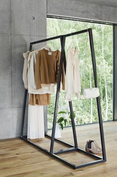 clothes are hanging on racks in front of a window