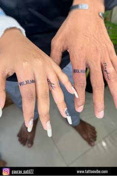 two people with matching tattoos on their hands and one holding the other's hand