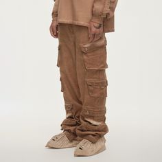 The Distressed Multi-Pocket Layered Cargo Pants in Earth perfectly merge street style with practicality. These cargo pants feature multiple flap pockets on both sides, providing ample storage and a rugged look. The elasticized cuffs create a natural stacking effect when worn, while zippers on the cuffs allow for an adjustable fit around the calves, enhancing mobility. The washed, distressed finish adds a unique edge to the design. Made from premium 100% cotton fabric, these slightly oversized pa Fall Full-length Cargo Pants With Multiple Pockets, Urban Parachute Pants With Patch Pockets, Streetwear Parachute Pants With Patch Pockets, Urban Baggy Parachute Pants With Multiple Pockets, Streetwear Full-length Parachute Pants With Patch Pockets, Baggy Techwear Parachute Pants With Multiple Pockets, Streetwear Full Length Parachute Pants With Patch Pockets, Baggy Techwear Pants With Pockets, Straight Leg Cargo Pants With Multiple Pockets For Fall