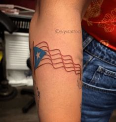 a person with a tattoo on their arm holding an american flag in the shape of a heart