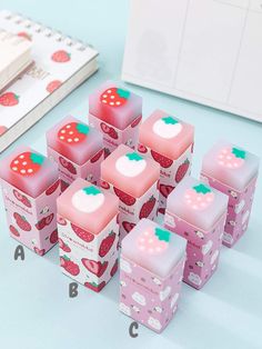 six strawberry shaped boxes are sitting on the table