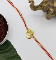 an elephant figurine next to a small metal bowl with red string on it