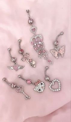 several different types of piercings are laying on a pink sheet with the word love written in