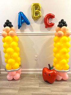 balloons are arranged in the shape of two corn on the cob, and an apple