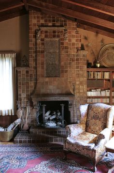 a living room filled with furniture and a fire place next to a book shelf full of books