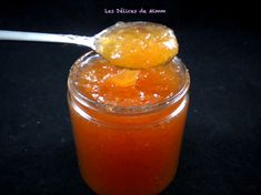 a spoon full of orange juice and some sugar on the rim with a piece of fruit in it