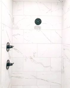 the shower head is mounted to the side of the wall with two faucets