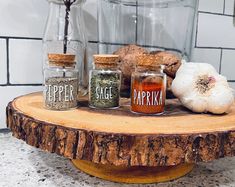 spices and garlic on a wooden table in front of a glass jar with pepper, paprika