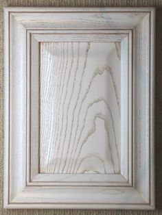 a white frame on the wall with wood grained in it's center and bottom