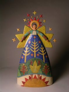 an angel figurine sitting on top of a blue and yellow cone shaped object