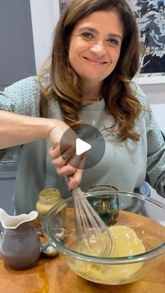 a woman mixing ingredients in a glass bowl