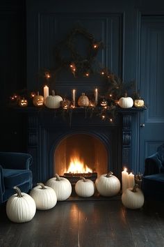 a fireplace with candles and pumpkins on the mantle, surrounded by other white pumpkins