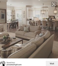 a living room filled with furniture next to a kitchen and dining room table in a home