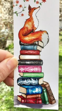 a hand holding up a card with a fox on top of books