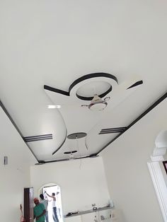 a man is painting the ceiling in a room with white walls and black trimmings