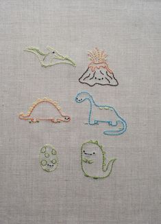 four different types of embroidered animals on white fabric