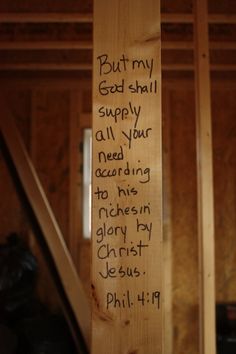 a wooden cross with writing on it in a room that is being built into the wall