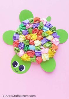 a turtle made out of colorful paper on a pink background