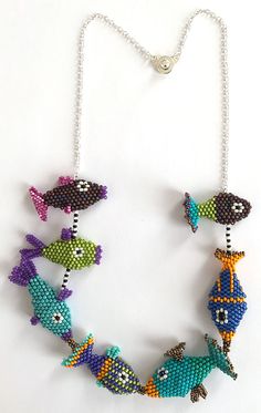 a necklace made with beads and fish on a chain