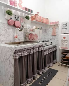 the kitchen is decorated in pink and grey colors with white walls, shelving above the sink