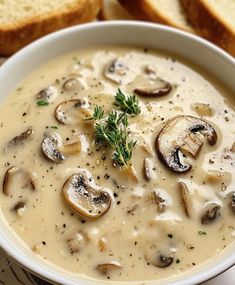 a bowl of mushroom soup with bread on the side