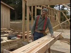 a man standing on top of a wooden floor next to a building under construction with wood framing