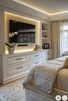 a bedroom with white furniture and a large flat screen tv mounted on the wall above the bed