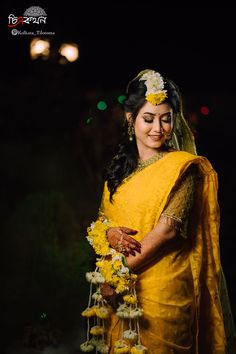 a woman in yellow is posing for the camera with flowers on her head and hands