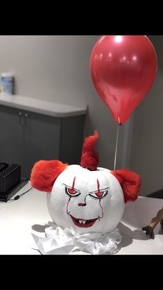 a balloon with a clown's face on it and a red balloon attached to it