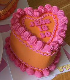 a heart shaped cake with pink icing on top