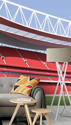 a living room with a couch, table and lamp in front of an empty stadium