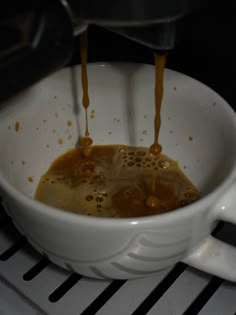 coffee being poured into a white cup