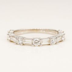 a white gold wedding band with three baguettes on the side and four diamonds in the middle