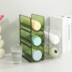 an assortment of bathroom items on a counter next to a glass cup and candle holder