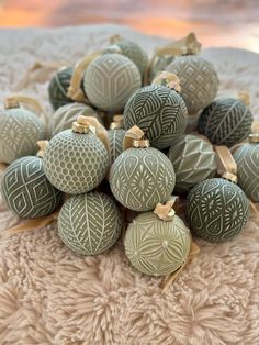 a pile of green ornaments sitting on top of a white blanket next to each other