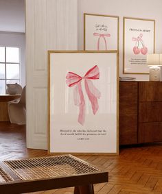 there are two framed pictures on the wall next to each other, one with a pink bow