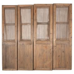 an old wooden room divider with four panels on each side and three doors in the middle