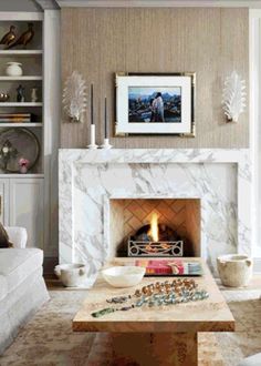 a living room filled with furniture and a fire place in front of a white fireplace