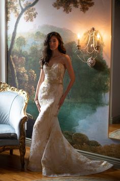 a woman standing in front of a painting wearing a wedding dress