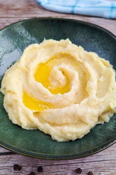 mashed potatoes on a green plate with an egg in the center