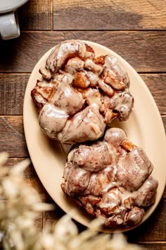 two cinnamon rolls on a plate with icing