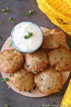 some food is sitting on a plate with a bowl of yogurt in the middle