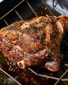 a piece of meat is being cooked on a grill grate with some spices sprinkled on it